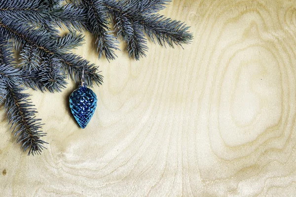 Різдвяний фон з ялиновими гілками та сосновим конусом на старому — стокове фото