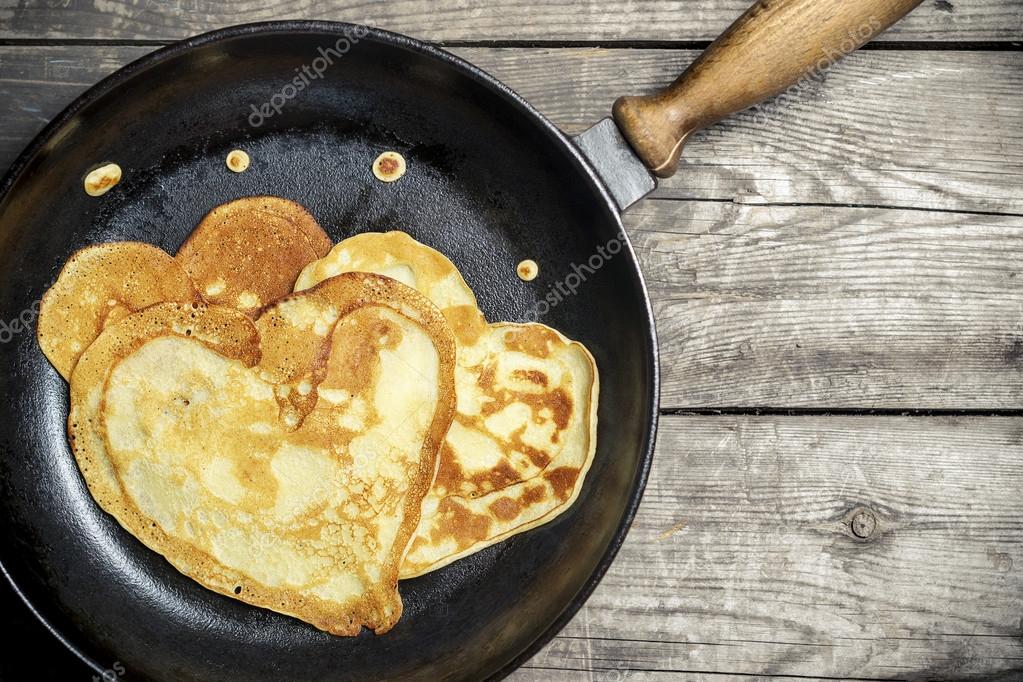 Fried pancakes - heart on a cast iron skillet . Top view . — Stock ...