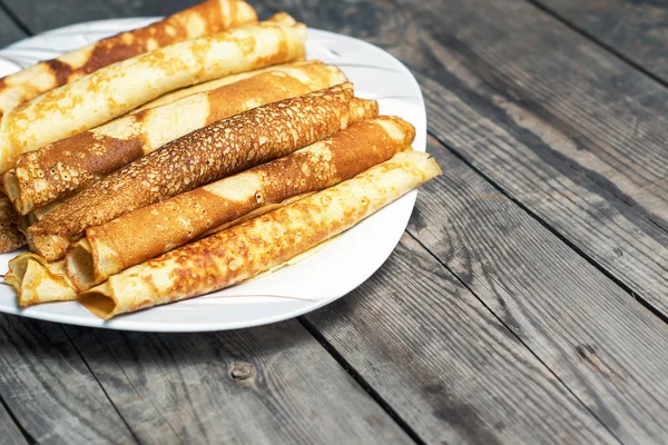 Gebratene Pfannkuchen auf dem Teller auf einem rustikalen Tisch. — Stockfoto