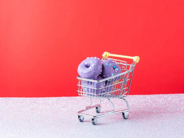 Миниатюрная Тележка Фиолетовыми Пончиками Изолированная Красном Серебряном Фоне — стоковое фото