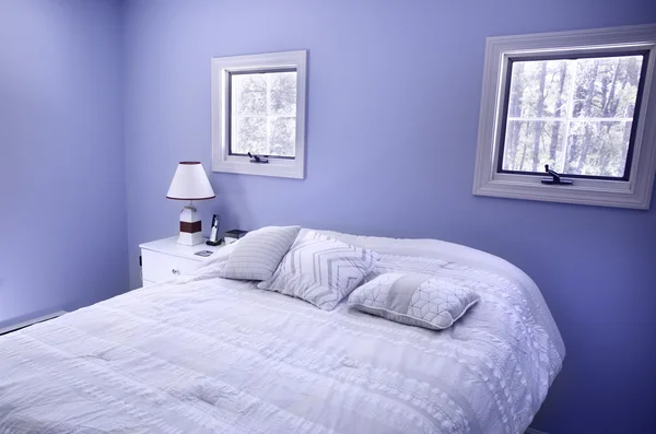 Bedroom with blue walls and windows in Wellfleet, MA on Cape Cod house.
