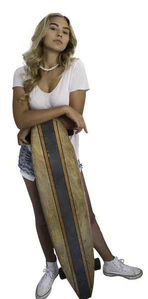 Bella ragazza bionda appoggiata sullo skateboard su sfondo bianco . — Foto Stock