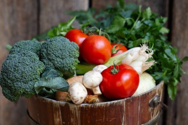 El yapımı domates, brokoli, yeşil soğan, kırsal bir kovada maydanoz.