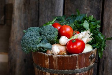 El yapımı domates, brokoli, yeşil soğan, kırsal bir kovada maydanoz.