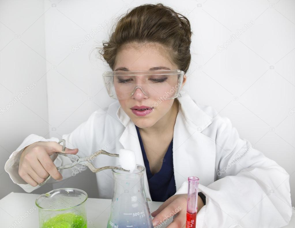 Teenage girl wearing goggles doing science experiment