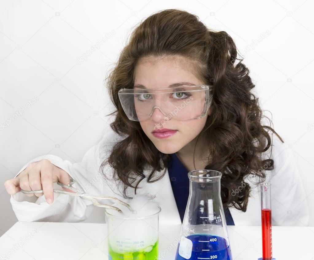 Teenage girl wearing goggles doing science experiment