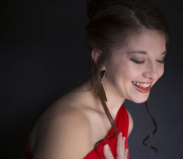 Pretty teenage girl laughing and wearing red prom dress — Stock Photo, Image