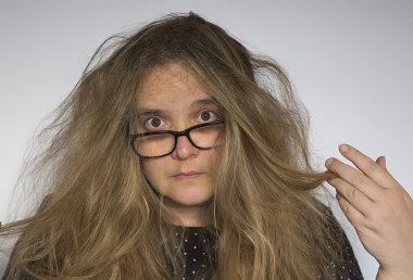 Orta yaşlı bir kadın saçlarını çekerek