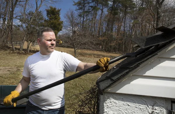 Man taking shingles off a shed roof — Stock Photo, Image