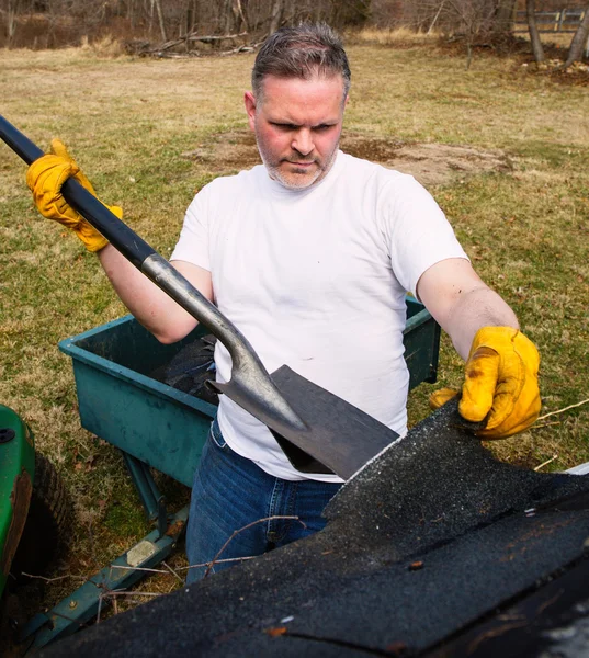 Man taking shingles off a shed roof — Stock Photo, Image