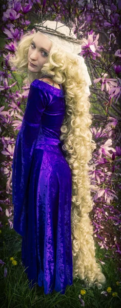 Genç kadın uzun sarı saçlı Rapunzel gibi giyinmiş.