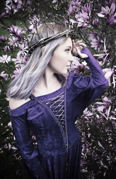 Jeune femme debout devant un arbre en fleurs — Photo