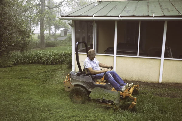 Homme coupe herbe sur l'équitation tondeuse à gazon — Photo