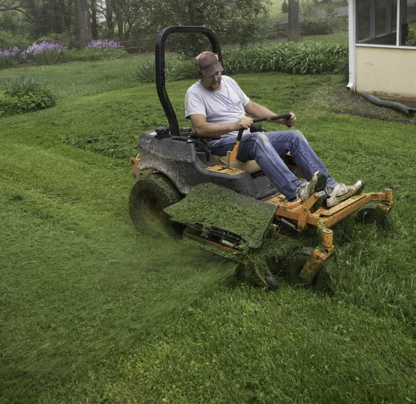 Homem cortando grama no cortador de grama — Fotografia de Stock