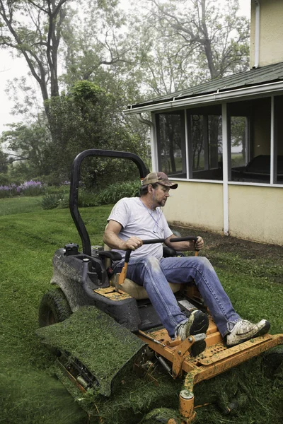 Homme coupe herbe sur l'équitation tondeuse à gazon — Photo