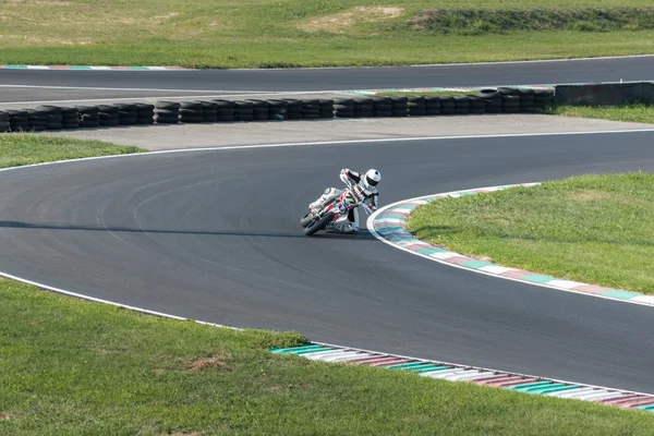 Racer taking a corner on a motorbike in a well known motorbike circuit — Stock Photo, Image