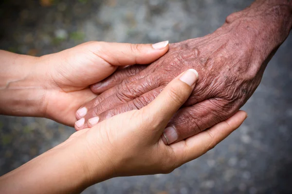 Büyük ve genç el ele tutuşuyorlar.