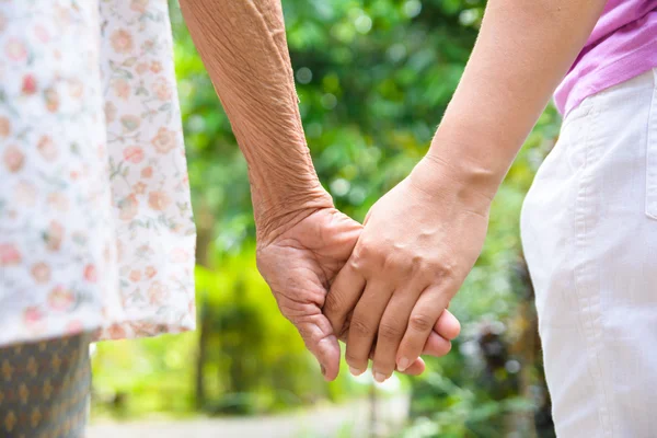 Büyük ve genç el ele tutuşuyorlar.