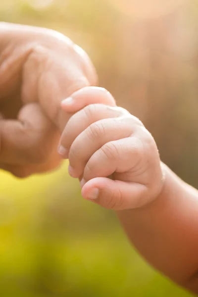 Baby hand met moeder vinger — Stockfoto