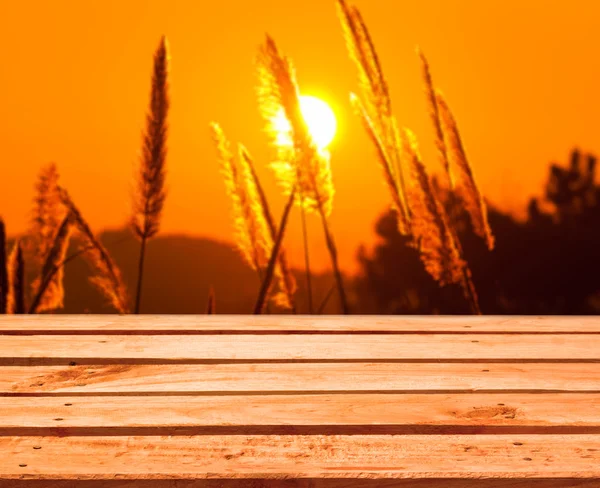 Leerer Holzdecktisch auf buntem Sonnenaufgangshintergrund Stockbild