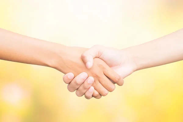 Shaking hands of two male people, on color nature background. — Stock Photo, Image