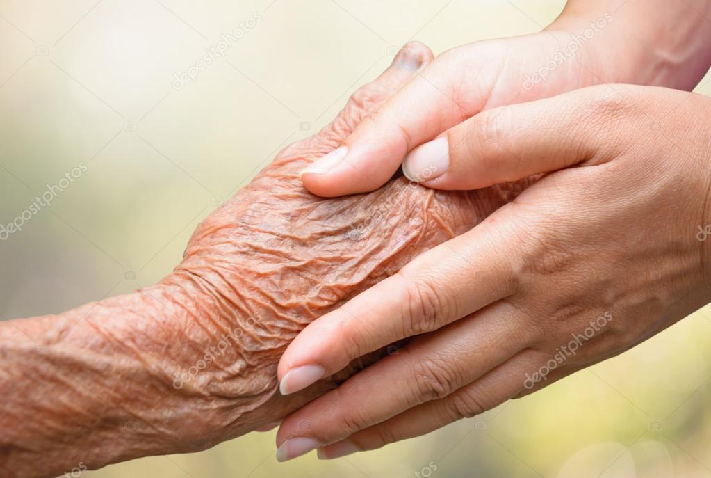 Senior and young holding hands