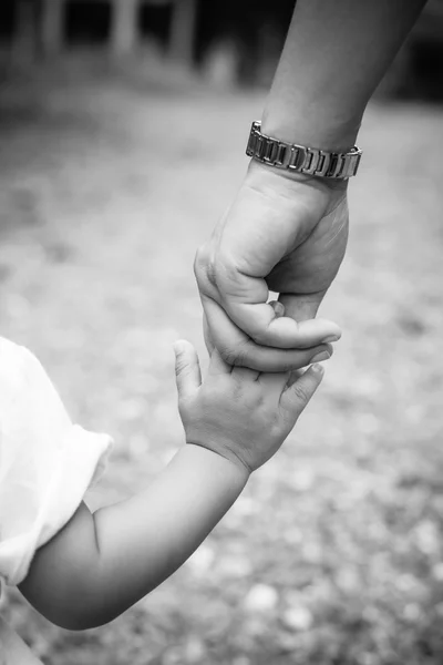 Mãe segurando uma mão de criança com efeito preto e branco — Fotografia de Stock