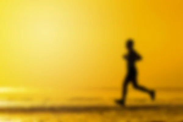 Размытый фон людей, бегущих по пляжу — стоковое фото