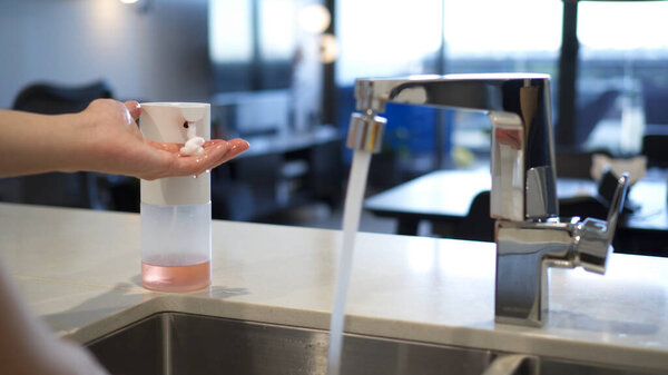 человек моет руки жидким мылом