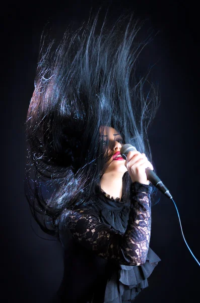 Kadının mikrofon, saç havada şarkı Stok Fotoğraf