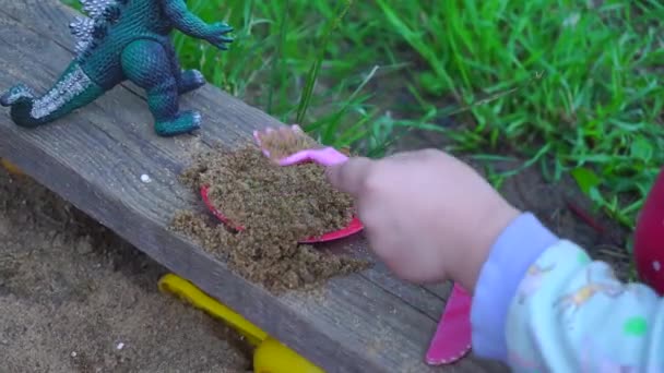 Un niño jugando en la caja de arena — Vídeos de Stock
