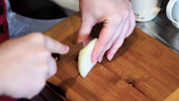 Mulher corta cebola. O processo de cortar as cebolas em uma placa de madeira . — Vídeo de Stock