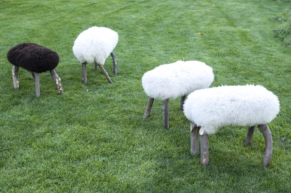 Pequeñas sillas de madera cubiertas con piel de oveja de prado —  Fotos de Stock