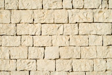 Güneşli bölgede eski beyaz taş duvar.