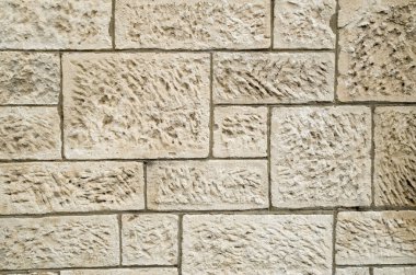 Güneşli bölgede eski beyaz taş duvar.