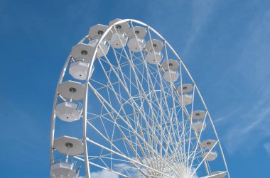 Mavi gökyüzünde bulutlu beyaz dönme dolap