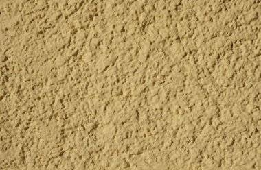 Sarı dekoratif yardım sıvası duvarda. 