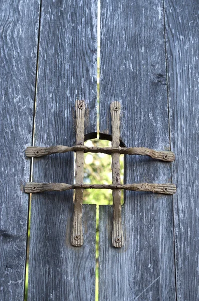 Oude houten deur met metalen raster kijkgaatje binnen — Stockfoto