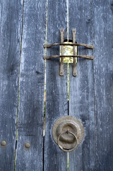 Oude houten deur met metalen raster kijkgaatje binnen en scharnier — Stockfoto