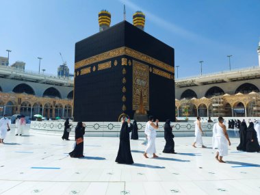 MECCA, SAUDI ARABIA , OCTOBER 22, 2020 - Pilgrims circle the Kaaba in the Grand Mosque - umrah Fewer Muslims people Socially Distanced corona virus wearing face mask clipart