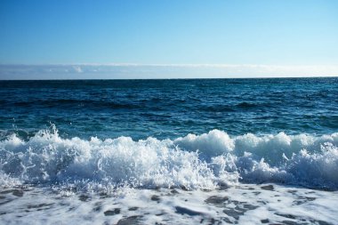 Sahilde beyaz köpüklü güzel mavi dalgalar