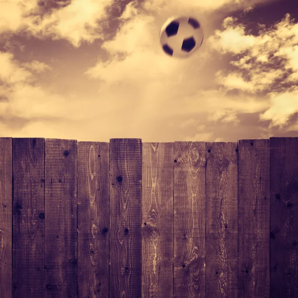 Деревянный забор и футбольный мяч — стоковое фото