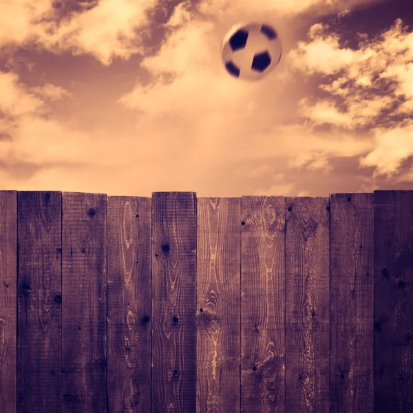 Деревянный забор и футбольный мяч — стоковое фото