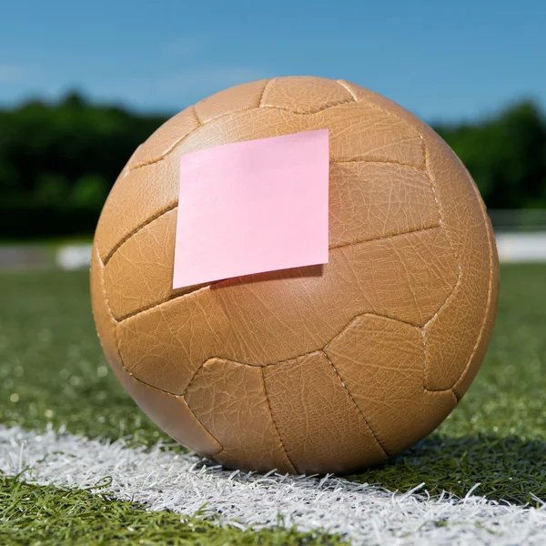 Футбольный мяч и липкая нота — стоковое фото