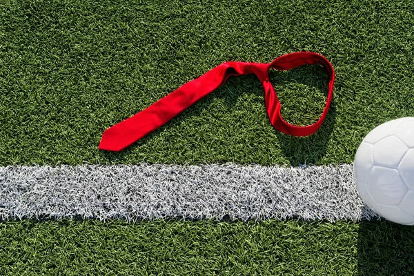 Pallone da calcio e cravatta su un campo da calcio — Foto Stock