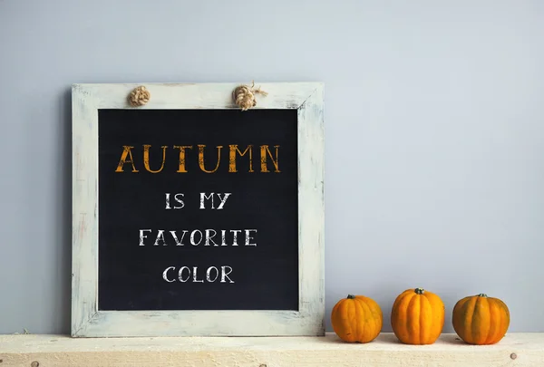 Cadre tableau noir sur le mur gris avec des livres citrouilles automne est — Photo