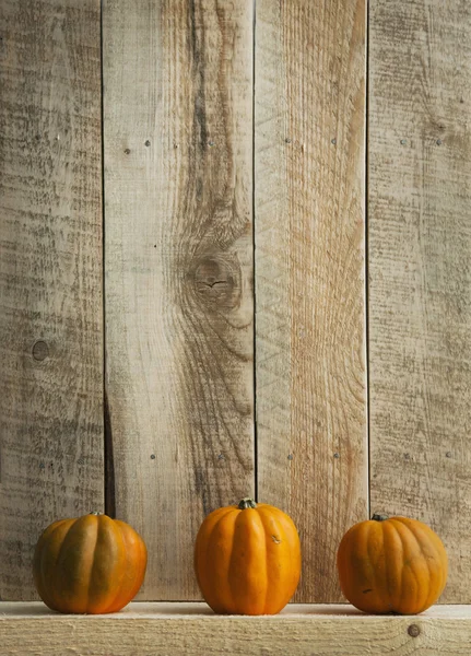 Tre zucche su sfondo vecchio di legno — Foto Stock