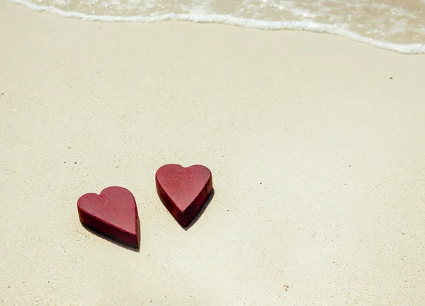 Two wooden red hearts on the sand — Stock Photo, Image