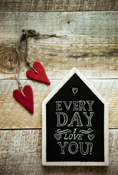 House shaped chalk board and two red vintage hearts — Stock Photo, Image