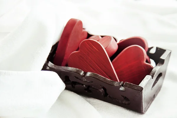 Caja llena de corazones de madera de San Valentín rojo — Foto de Stock